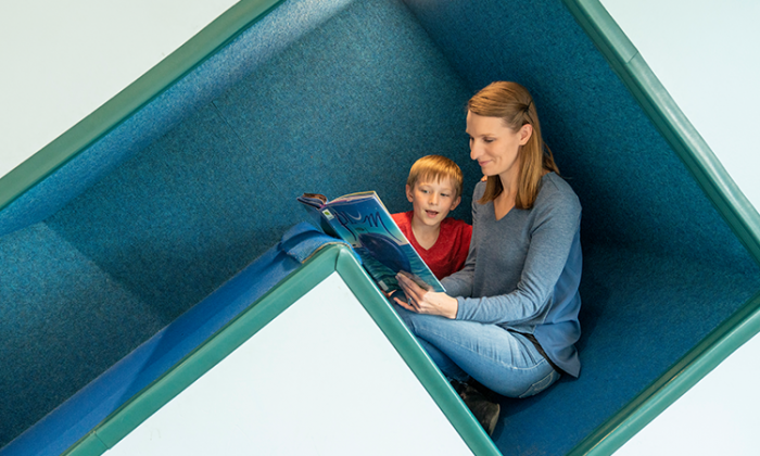 amy and son reading a book while in the library in juneau alaska