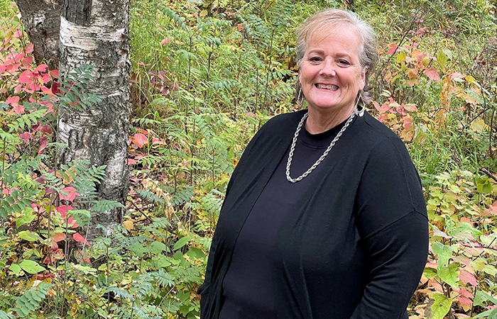 shannon posing in front of fall foliage in anchorage alaska