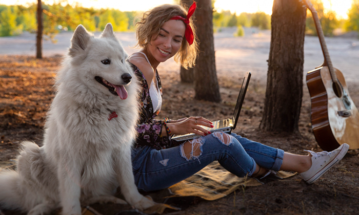 WOMAN WITH DOG OUTDOORS ON A LAPTOP