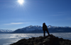 melissa standing on rock with water and mountains in the distance