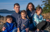 stephen pictured with his wife and children outdoors with the water behind them